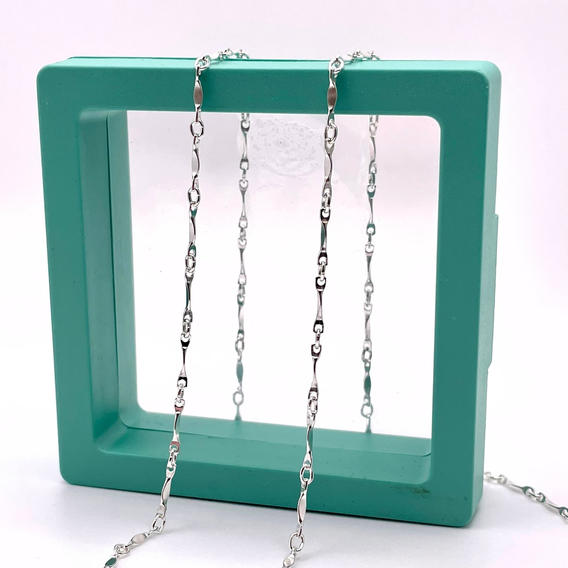 Sterling silver dapped bar chain for permanent jewelry in a hallow green box.