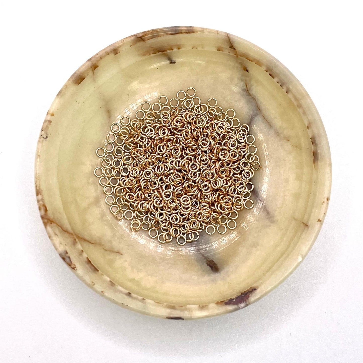 Bulk Yellow Gold Filled Jump Rings on a bowl.